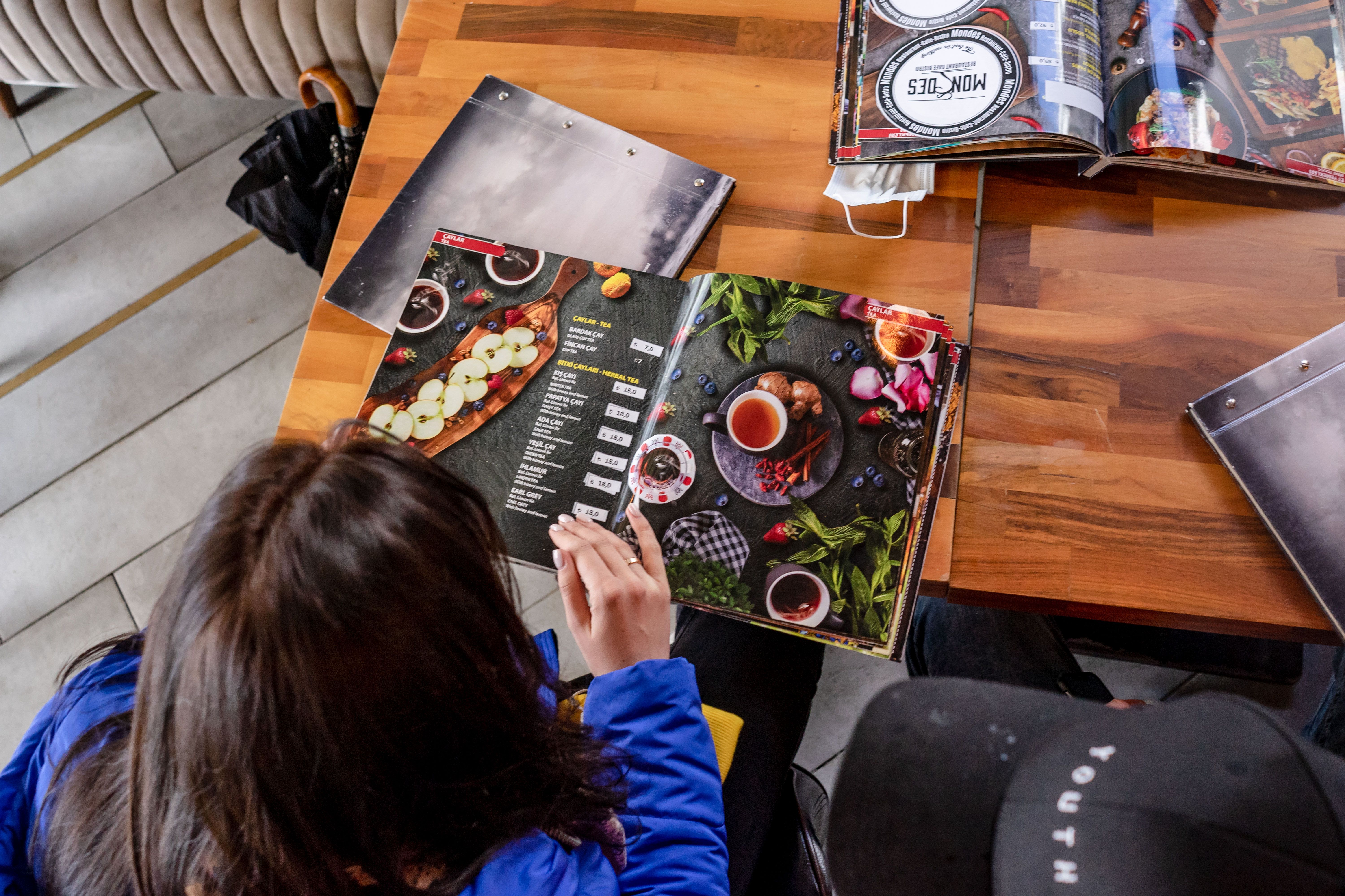 Two diners reviewing food menus together at a cafe, illustrating how transparent menu details can support confident choices.