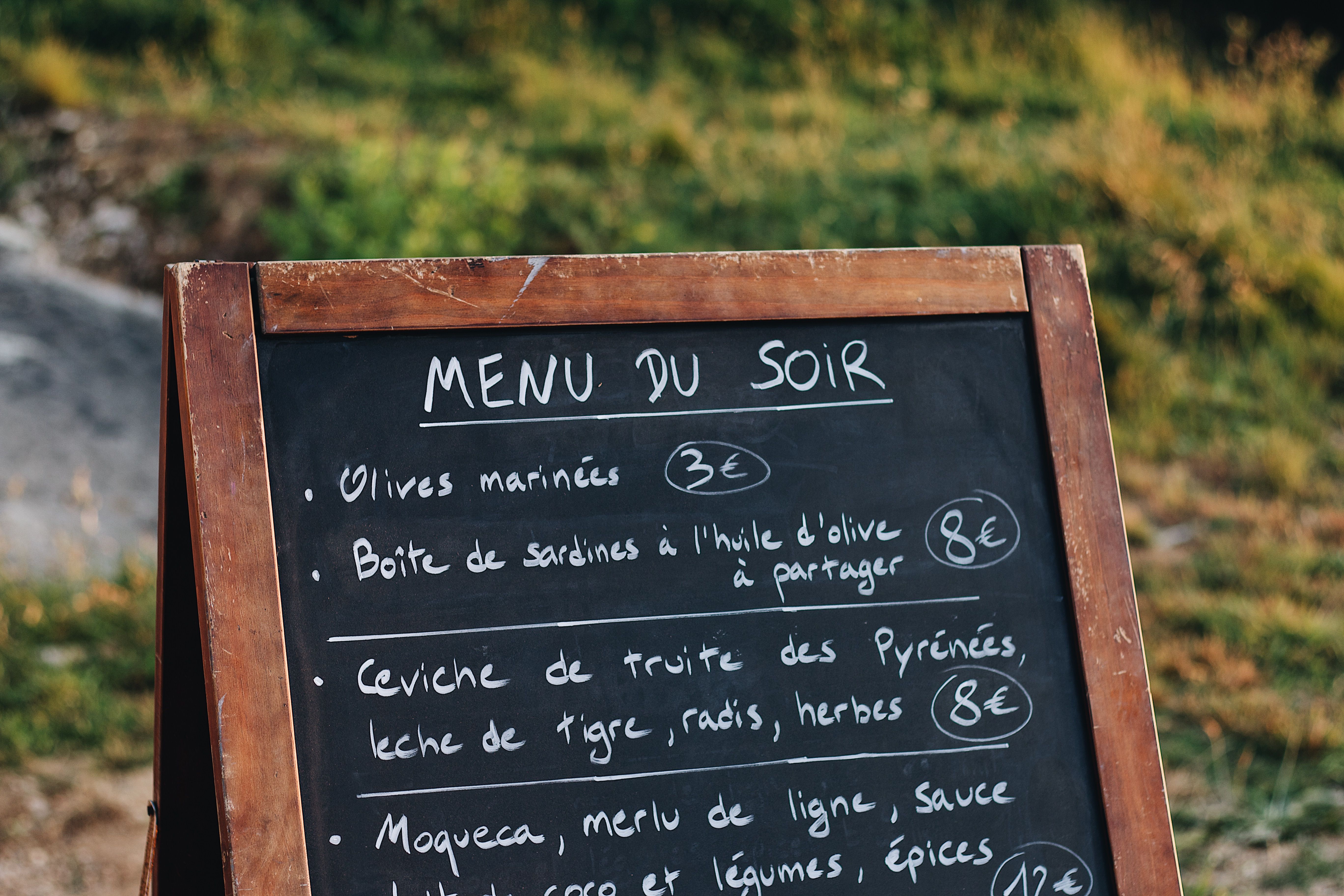 A restaurant chalkboard menu displayed outdoors, highlighting the role of visible and accessible menu information.